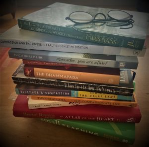 Stack of books with a pair of glasses on top.